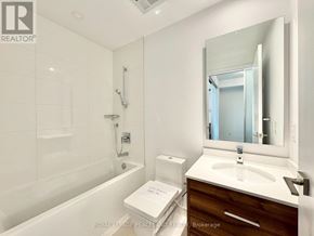 Toronto (Kensington-Chinatown) condo for rent - A white bathroom with a tub, sink, and mirror.