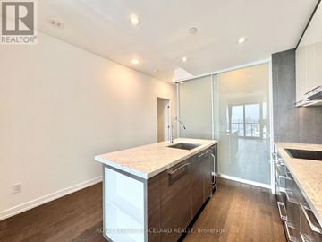 Toronto (Kensington-Chinatown) condo for rent - A kitchen with a white countertop and wooden cabinets.