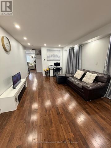 Cambridge apartment for rent - A living room with a brown leather couch and wooden floors.