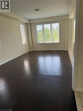Cambridge apartment for rent - A room with wooden floors and a window overlooking a green area.