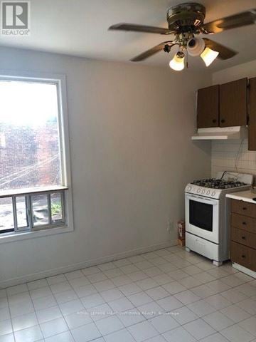Toronto (Dufferin Grove) multi-family for rent - A kitchen with a white stove and a ceiling fan.