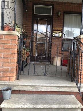 Toronto (Dufferin Grove) multi-family for rent - A metal gate is in front of a brick house.