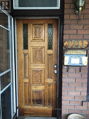 Toronto (Dufferin Grove) multi-family for rent - A wooden door with a glass window above it.