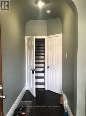 Toronto (Dufferin Grove) multi-family for rent - A hallway with a staircase and a door.