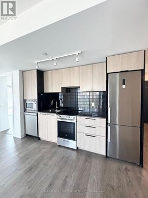 Toronto (Church-Yonge Corridor) condo for rent - A modern kitchen with stainless steel appliances and wooden cabinets.