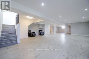 Georgina (Pefferlaw) apartment for rent - A spacious room with wooden flooring and a staircase on the left side.
