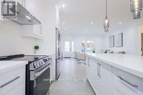 Georgina (Pefferlaw) apartment for rent - A modern kitchen with white cabinets and a black stove top oven.