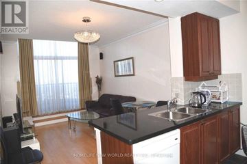 Toronto (Willowdale East) condo for rent - A living room with a black couch and a glass table.