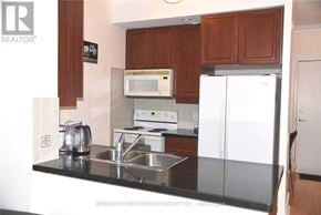 Toronto (Willowdale East) condo for rent - A kitchen with a sink, stove, and refrigerator.