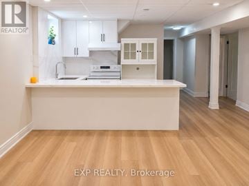 Toronto (Woburn) apartment for rent - A kitchen with white cabinets and a wooden floor.
