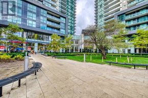 Toronto (Willowdale West) condo for rent - A walkway with a bench and trees in front of apartment buildings.