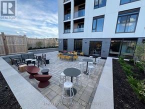 Milton (Fo Ford) condo for rent - A patio area with tables and chairs in front of a building.