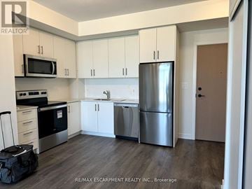 Milton (Fo Ford) condo for rent - A kitchen with white cabinets and a stainless steel refrigerator.