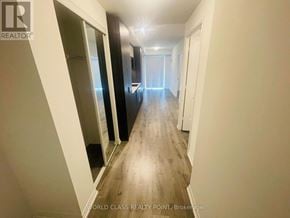 Toronto (Waterfront Communities) condo for rent - A long hallway with a door at the end.