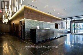 Toronto (Bay Street Corridor) condo for rent - A reception area with a dark wood and glass wall.