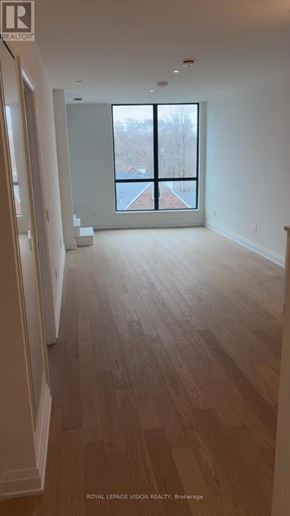 Toronto (Englemount-Lawrence) condo for rent - A long hallway with wood floors and a large window.