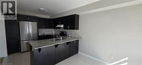 Ayr apartment for rent - A kitchen with black cabinets and a stainless steel refrigerator.