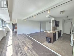 Toronto (Malvern) condo for rent - A spacious room with wooden flooring and a kitchenette area.