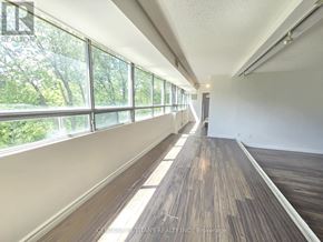 Toronto (Malvern) condo for rent - A long hallway with wood floors and windows on one side.