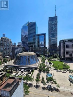 Toronto (Waterfront Communities) condo for rent - A cityscape with a large building in the center and several skyscrapers in the background.