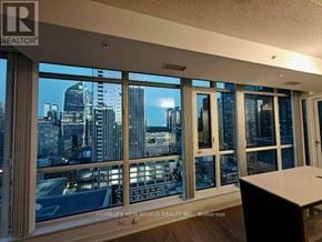 Toronto (Waterfront Communities) condo for rent - A room with a view of the city skyline through large windows.
