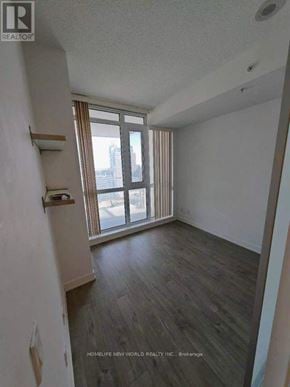 Toronto (Waterfront Communities) condo for rent - A room with a large window and wooden flooring.