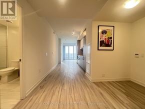 Toronto (Waterfront Communities) condo for rent - A hallway with wood floors and white walls.