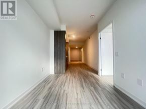 Toronto (Waterfront Communities) condo for rent - A long hallway with wood flooring and white walls.