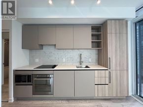 Toronto (Waterfront Communities) condo for rent - A modern kitchen with a sink, stove, and cabinets.