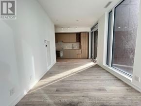 Toronto (Waterfront Communities) condo for rent - A spacious room with a kitchen area in the background.