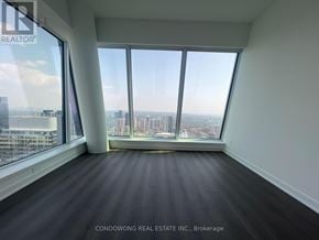 Toronto (Bay Street Corridor) condo for rent - A room with a large window overlooking a cityscape.