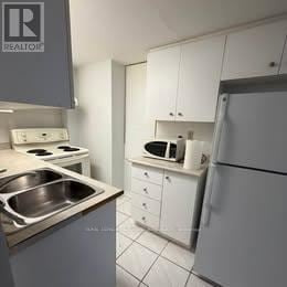 Mississauga (East Credit) apartment for rent - A kitchen with a stove top oven, microwave, and refrigerator.