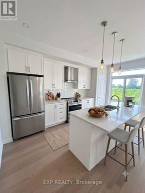 Ottawa townhouse for rent - A modern kitchen with white cabinets and a large island.