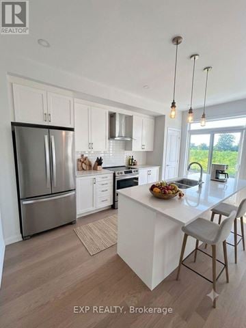 Ottawa townhouse for rent - A modern kitchen with white cabinets and a large island.