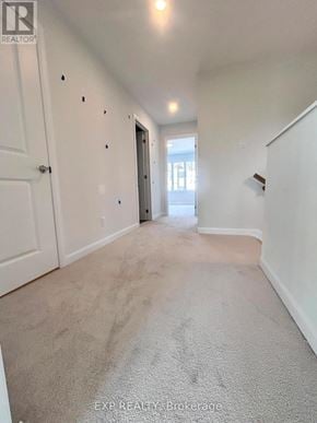 Ottawa townhouse for rent - A hallway with a carpeted floor and white walls.