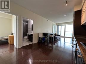 Toronto (Bay Street Corridor) condo for rent - A spacious living room with hardwood floors and a kitchen area in the background.