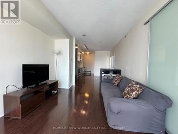 Toronto (Bay Street Corridor) condo for rent - A living room with a grey couch and a wooden entertainment center.