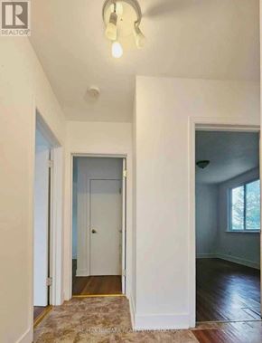 Niagara Falls (Hospital) apartment for rent - A hallway with a rug on the floor and a door on the left.