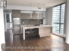 Toronto (Waterfront Communities) condo for rent - A modern kitchen with a bar stool and a refrigerator.