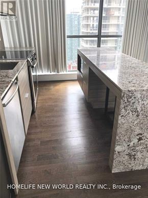 Toronto (Waterfront Communities) condo for rent - A kitchen with a marble countertop and wooden flooring.