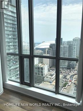 Toronto (Waterfront Communities) condo for rent - A window with a view of a cityscape and a parking lot.