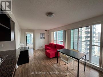 Toronto (Bendale) condo for rent - A living room with a red couch and a black table.