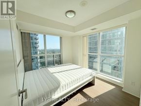 Toronto (Bendale) condo for rent - A bedroom with a large bed and a view of the city.