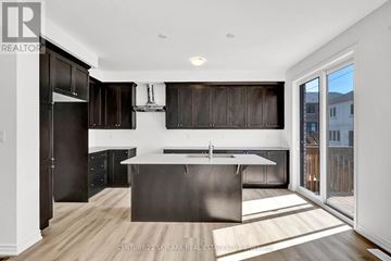 Barrie apartment for rent - A modern kitchen with dark wood cabinets and a large island.