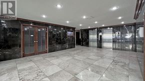 Toronto (Black Creek) condo for rent - A lobby with marble floors and a glass wall.