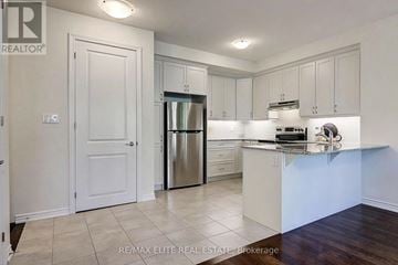 Markham (Victoria Square) townhouse for rent - A kitchen with white cabinets and a stainless steel refrigerator.
