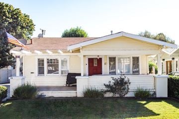 Fullerton apartment for rent - A white house with a red door and a black bench in front.