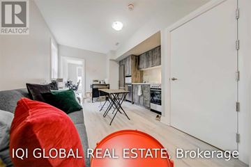 Toronto (Trinity-Bellwoods) apartment for rent - A modern living room with a grey sofa and a red bean bag chair.