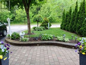Oshawa (Vanier) apartment for rent - A well-maintained garden with a brick pathway and a variety of plants and flowers.