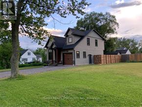 Fort Erie (Crystal Beach) apartment for rent - A house with a large front yard and a tree in the foreground.
